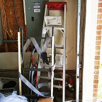 Photo shows 10 ft aluminum ladder with paint tray, 3 ft metal step ladder, and furniture dolly with straps in garage setting.