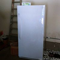 Front view of tall white upright freezer with handle and Kenmore logo.