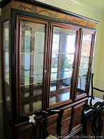 Front and side views of Asian inspired china cabinet with glass panels and wooden inlay doors.