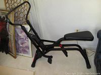 View of the Weslo Cardio Glide exercise machine from a side angle showing padded seat and foot pedals.