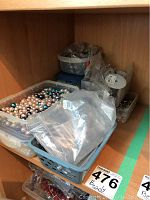 Overview of nine plastic containers holding various beads and accessories, mostly pearl-like beads in multiple colors, with bags and spools