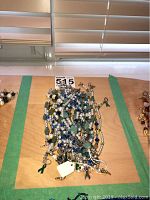 Top view of a pile of bracelets featuring faux pearls, green and blue beads with silver-tone metal chains and small charms.