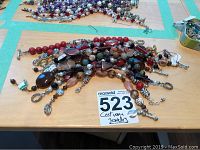 Overview of multiple costume jewellery bracelets arranged on a table showing a variety of bead colors and metal accent closures.