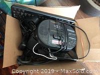 Box containing Logitech keyboard, Bose mini speakers, several cords, and other electronics.