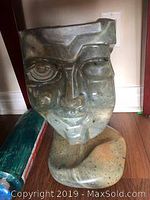 Front view of jade stylized face sculpture showing geometric facial features.
