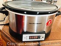 Hamilton Beach slow cooker with digital interface and glass lid on wooden table