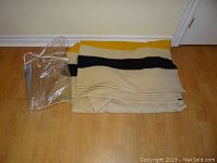Folded wool blanket with its clear protective bag visible