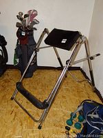 Side view of Invertrac medical device showing padded armrest and footrest with metal frame