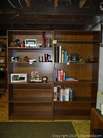 Front view of two wooden book shelves with various small items and books on them, showing shelf design and dimensions.