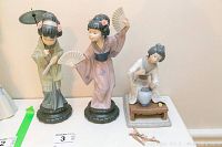 All three figurines displayed side by side on table