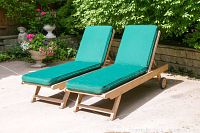 Front view of both teak lounge chairs with green cushions on patio