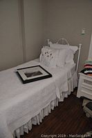 Room setup showing headboard, pillows, bedspread