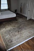 Full view of rug under bed in bedroom, showing overall pattern and size
