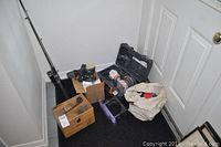 General view of all items together in corner including shoe shine box, sanding tools, waxing stand, fishing rod.