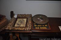 Wide view of four wall decor items placed on a furniture surface, showing all items together