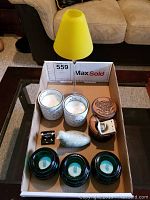 Overview of all items in the lot including yellow candle lamp, carved bird, wooden box, candles, and tea light holders.