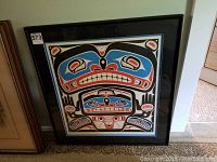Framed indigenous art print showing bold colors and traditional design motifs, with visible numbering and signature.