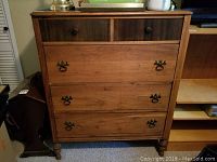Front view of the solid wood five drawer antique dresser showing drawer arrangement and handles.