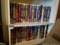 Shelf of Disney VHS tapes showing titles including Aladdin, Bambi, The Aristocats, The Lion King, Beauty and the Beast, and The Emperor's New Groove.