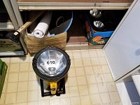 Front view of the large 1 million candle power portable spotlight in yellow and black on the floor