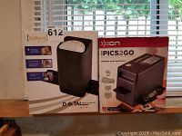 Two boxed digital scanners displayed side by side including VuPoint digital film scanner and ION PICS2GO slide and negative scanner.