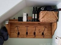 Front view of the full farmhouse wooden coat rack mounted on wall showing four metal hooks, hanging rings, and upper shelf
