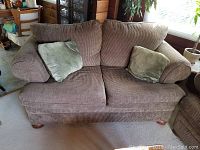 Front view of The Brick brown fabric sofa with decorative pillows