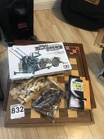 Lot contents including wooden chess board, chess pieces in plastic bags, Scrabble game box, and Tamiya German military model kit box. Nintendo DS is visible in the lot but not the main focus.