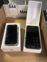 Back view of Apple iPhone SE in box alongside Samsung phone in box