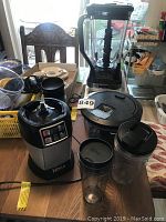 Overview of Ninja blender and smoothie maker with multiple attachments on table