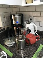 Overview of all kitchen beverage appliances including coffee maker, electric kettle, espresso maker, tea pot, coffee grinder on countertop