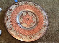 Full view of the round copper plate showing all ornate patterning with copper and silver metalwork.
