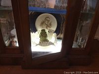 Display cabinet showing Franklin Roosevelt souvenir plate and incense burner inside