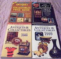 Four Antique Trader price guides displayed flat on a surface, showing covers with images of antiques and collectibles.