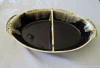 Top-down view of oval divided brown glazed drip bowl
