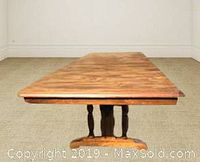 Side angle showing the rectangular solid wood dining table with carved pedestal base and support legs