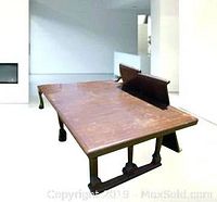 Rectangular wooden dining table with two removable leaves, showing wear and damage on the surface.