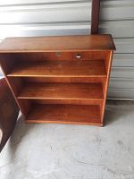 Image of a small wooden book shelf with three shelves showing smooth finish and compact design