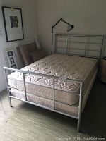 Full view of the silver grey metal bed frame set up with a mattress to show fit and design.