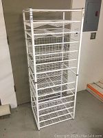 Full front and side view of the white Elfa stacking shelves showing frame, shelves, and wire basket drawers.
