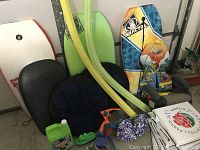Photo showing assortment of boogie boards, pool noodles, padded seat cushions, bubble toys, and seat pads.