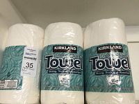 Six rolls of Kirkland Create-a-Size paper towels and one small package of napkins with MaxSold label