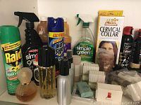 Photo of assorted household items including insecticide spray, multipurpose cleaner, small bottles, and a cervical collar box.