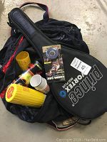 Photo of tennis racquet in cover, various tennis accessories and large sports bag