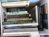 Books stacked showing titles covering history, sports, and negotiation.