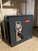 Closed view of Honeywell safe showing combination dial, key lock with keys inserted, and Honeywell logo on front door.