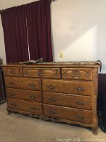 Front view of the carved wood dresser with nine drawers, showing overall size and wood finish.