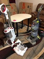 Two cleaning machines on carpet: white and red Shark Rotator vacuum and gray and green Hoover carpet washer along with their attachments.