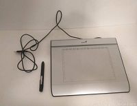 Full view of the Genius USB drawing pad with stylus and extra tips placed beside it and USB cable in view.