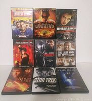 Photo showing nine assorted DVDs arranged in three rows of three, titles visible and clear.